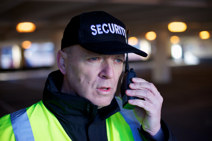 Ein Sicherheitsmitarbeiter kommuniziert per Handsprechfunkgerät